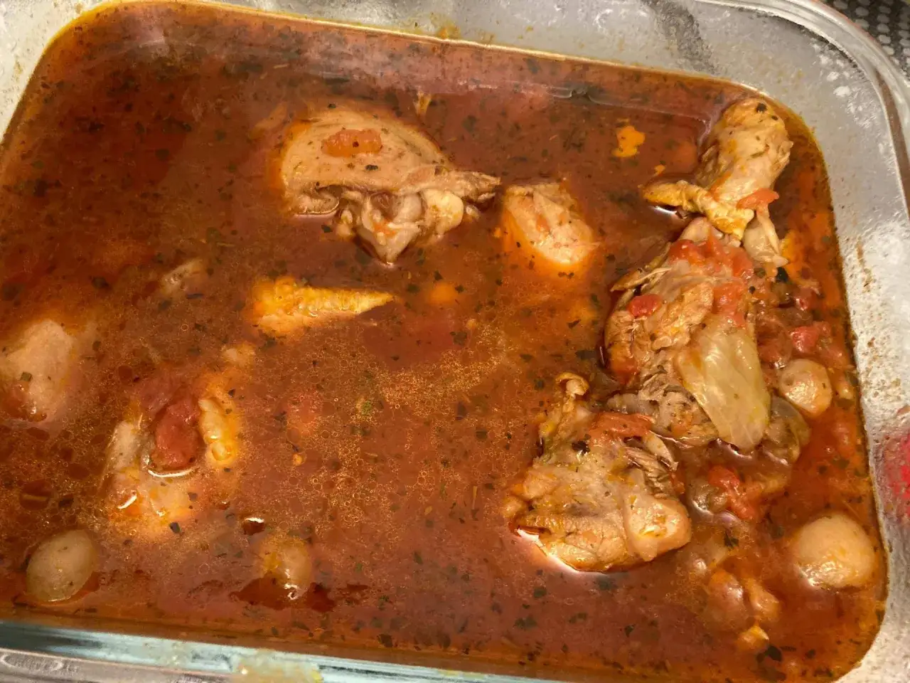 Un plat de cuisse de poulet cookeo mijoté dans une sauce tomate savoureuse avec des herbes et des petits oignons.