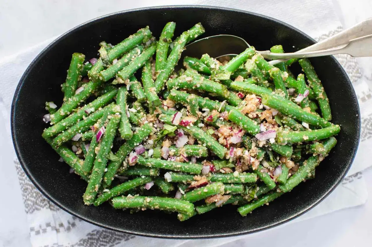 Salade de haricots verts croquants, assaisonnée d'oignons rouges et d'une vinaigrette savoureuse. Un délice frais et coloré.