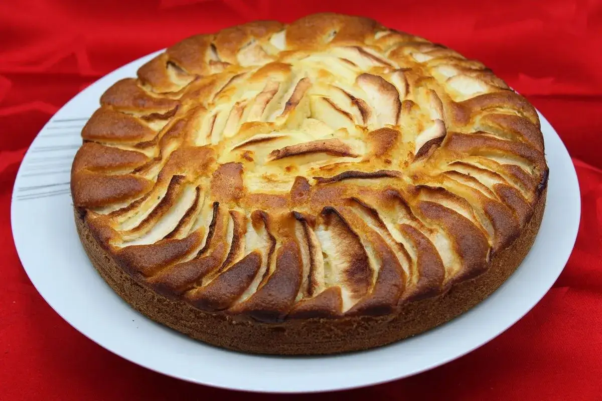 Gâteau yaourt pomme doré, aux fines lamelles de fruits disposées en rosace sur une pâte moelleuse. Un délice maison !