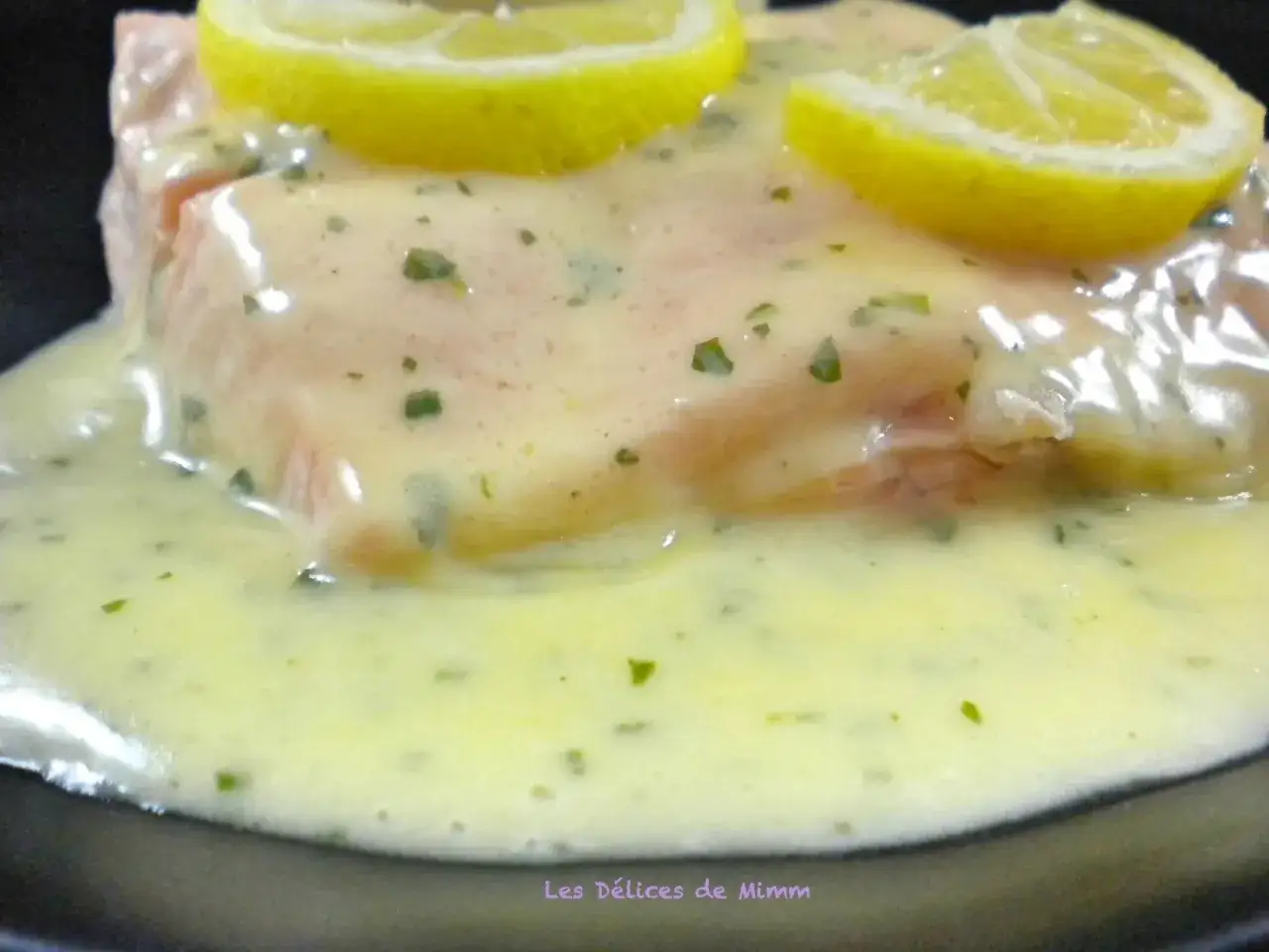 Un délicieux morceau de poisson nappé d'une onctueuse sauce pour poisson, garni de fines rondelles de citron.
