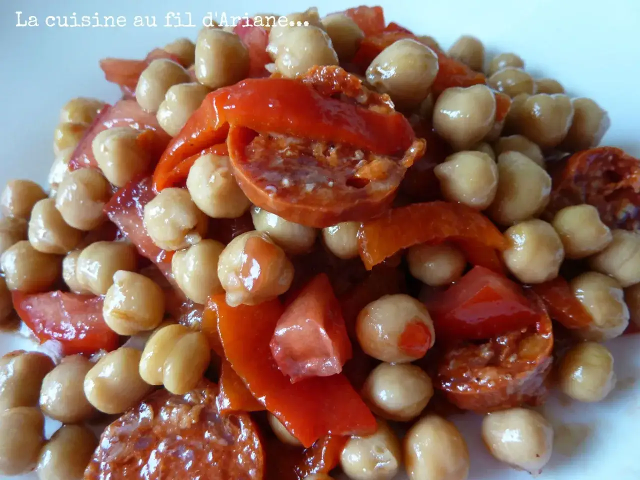 Un plat coloré de pois chiches, tomates et poivrons au four, prêt à être dégusté.