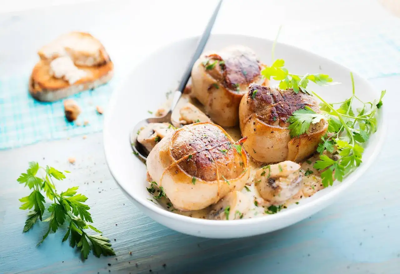 Paupiettes de veau savoureuses, préparées au Cookeo, servies dans une sauce crémeuse aux champignons et garnies de persil frais.