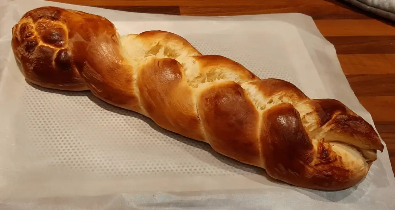 Une belle brioche maison rapide, tressée et dorée, prête à être dégustée.