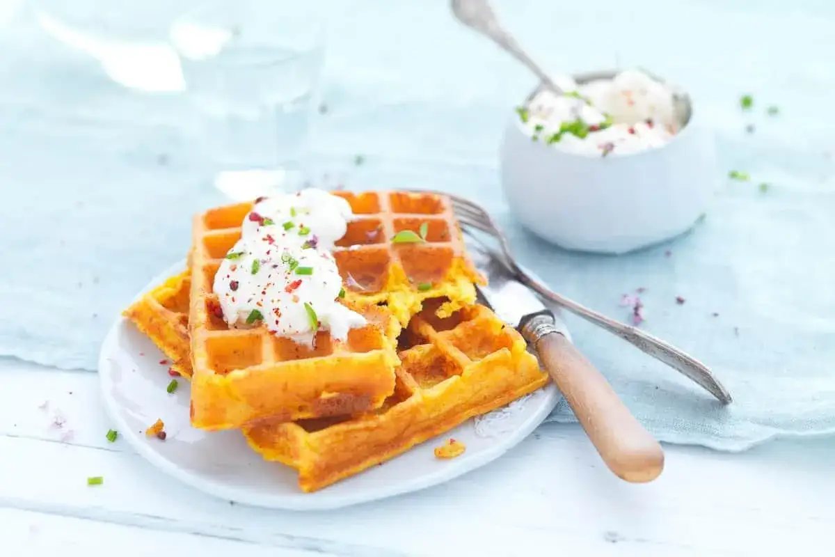 Gaufre patate douce dor&eacute;e, garnie de cr&egrave;me et de ciboule. Un d&eacute;lice sain pour le petit-d&eacute;jeuner ou le go&ucirc;ter.