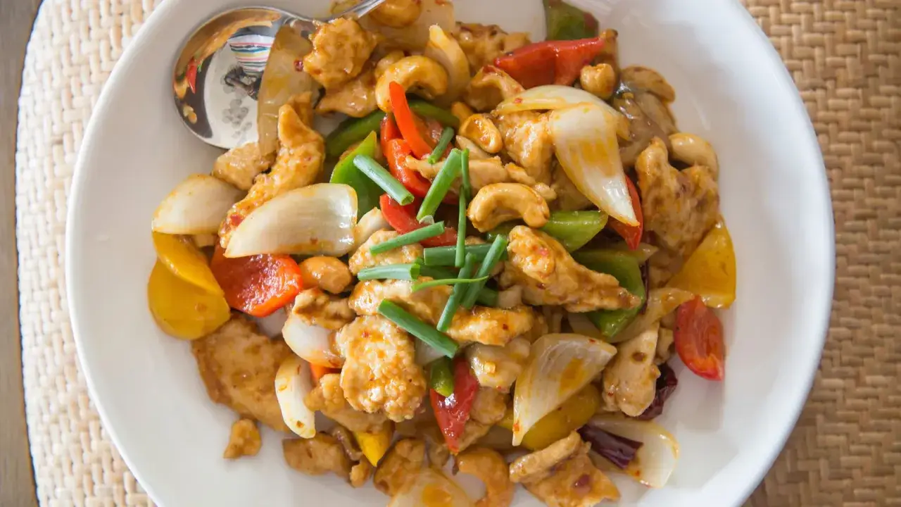 Un plat coloré de poulet aux noix de cajou, poivrons, oignons et ciboule. Un délice croustillant et savoureux.