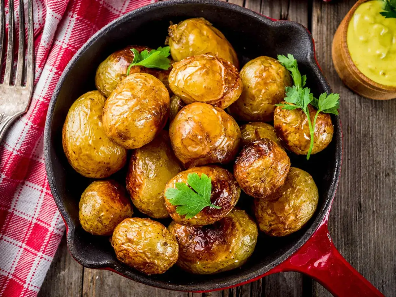 Poêlée de pommes de terre grenaille au four, dorées et garnies de persil frais, prêtes à être dégustées avec une sauce crémeuse.