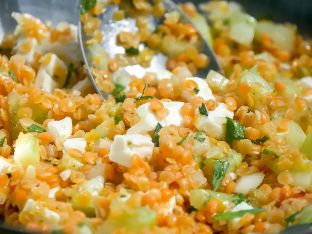 Salade colorée de lentilles corail, dés de feta et concombre, garnie d'herbes fraîches. Une bouchée pleine de saveurs et de fraîcheur.