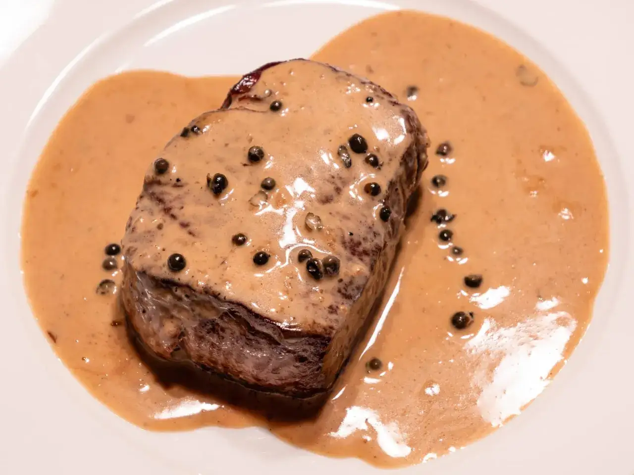 Un steak tendre nappé d'une onctueuse sauce au poivre, un classique de la recette sauce au poivre.