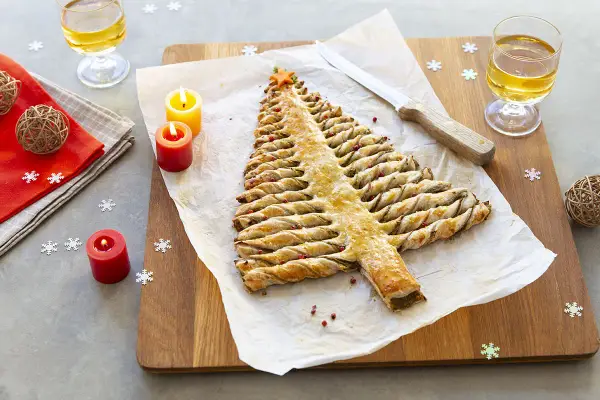 Une délicieuse entrée de Noël à faire la veille : un sapin feuilleté doré, décoré de baies roses, prêt à être dégusté.